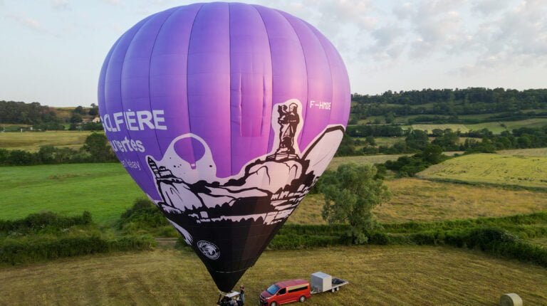 Montgolfière violette et son équipe au sol avant le vol